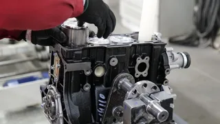 Worker assembling a motor on a factory bench